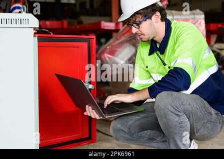 Technician engineer holding robot controller checking and repairing machine Stock Photo