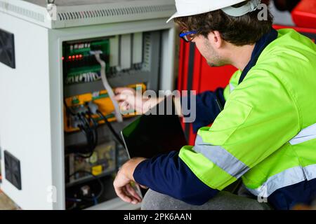 Technician engineer holding robot controller checking and repairing machine Stock Photo