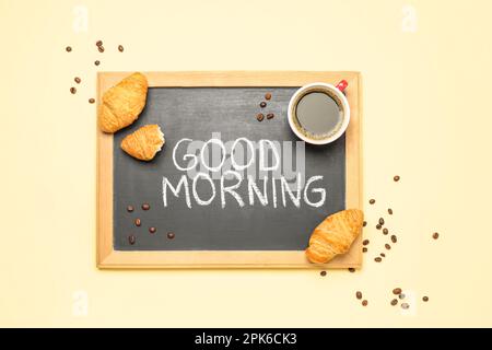Chalkboard with text GOOD MORNING, cup of coffee, beans and croissants on color background Stock Photo