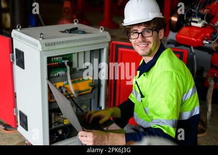 Technician engineer holding robot controller checking and repairing machine Stock Photo