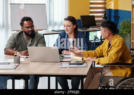 Diverse marketing department team talking at meeting after watching product presentation on laptop Stock Photo