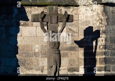 Stone cross with shadow cast, cathedral cemetery near Cologne Cathedral, Cologne, North Rhine-Westphalia, Germany Stock Photo