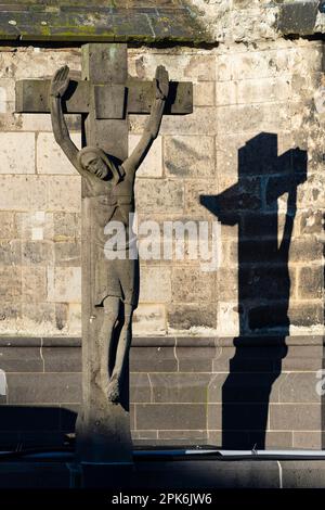 Stone cross with shadow cast, cathedral cemetery near Cologne Cathedral, Cologne, North Rhine-Westphalia, Germany Stock Photo