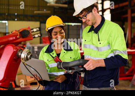 Technician engineer holding robot controller checking and repairing machine Stock Photo