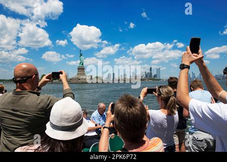 Tourists photographing the Statue of Liberty from the ferry, Manhattan, New York City, USA Stock Photo