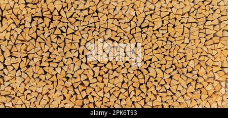 Large firewood wood pile made up of many small brown pieces of wood Stock Photo