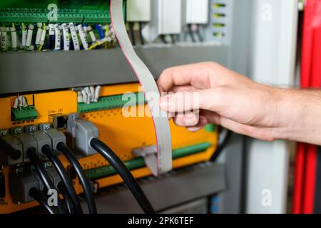 Technician engineer holding robot controller checking and repairing machine Stock Photo