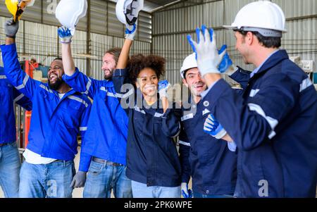 Group of happy engineers workers team smiling and standing at factory Stock Photo