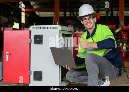 Professional male technician worker in white helmet checking machine maintenance Stock Photo