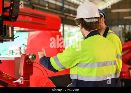 Two technicians workers with safety uniform using laptop talking Stock Photo