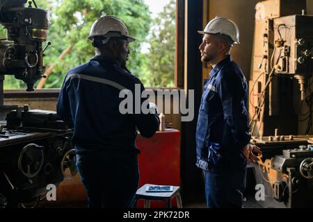Two industrial engineers team with safety uniform talking Stock Photo