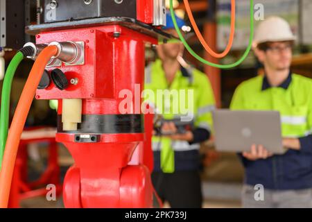 Two technicians workers with safety uniform using laptop talking Stock Photo