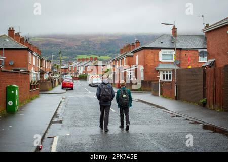 Secondary school children pupils students walking home after school through  West Belfast, County Antrim, Northern Ireland, UK Stock Photo