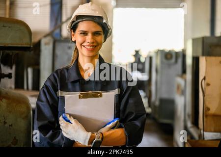 Happy female industrial worker holding clipboard paperwork Stock Photo