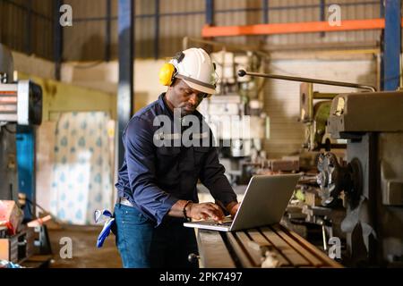 Male technician specialist with safety uniform using laptop Stock Photo