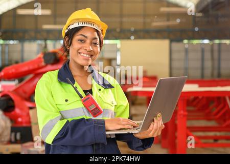 Professional female mechanical engineer in yellow hard hat and safety uniform Stock Photo