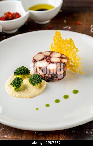 Octopus terrine or octopus carpaccio with sauces on a white porcelain plate Stock Photo