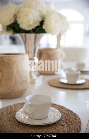 Cup of coffee on the table in modern living room with flowers Stock Photo
