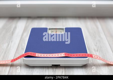 red measuring tape taken with a shallow depth of field. red measuring tape lies on the scales. diet and weight loss. High quality photo Stock Photo