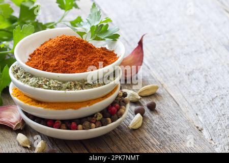 Herbs and spices in bowls on wooden boards background Stock Photo
