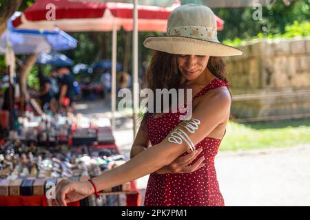 Tourist buying a costume jewelry bracelet and souvenirs at a street stall selling costume jewelry and gifts at the amazing site of the Kulkulcan pyram Stock Photo