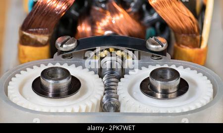 Close-up of electric motor transmission plastic gear wheels, metal worm screw and ball bearing. Rotor and stator copper wire winding inside old mixer. Stock Photo