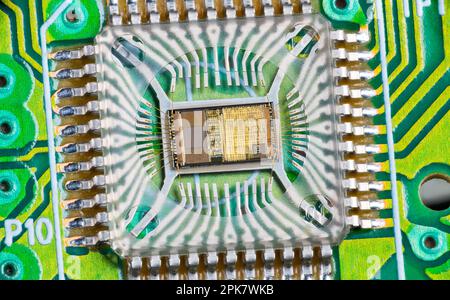 Closeup of electronic integrated circuit die with photodiode array and gold wires on green PCB. Micro chip inside optical computer mouse image sensor. Stock Photo