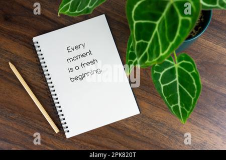 Short inspirational quotes text on note pad - Every moment is a fresh beginning Stock Photo