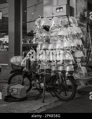 A battered Honda scooter overloaded with plastic bags containing goldfish in plastic bags filled with water in Pleiku, Vietnam. Stock Photo