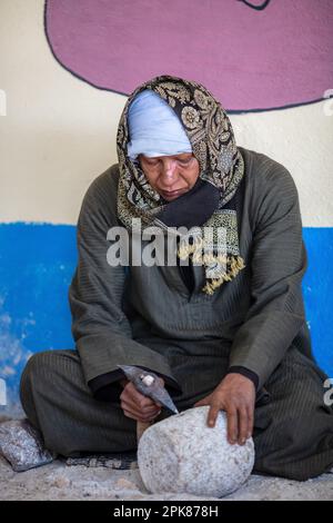 Luxor, Egypt - January 17, 2019: A man is processing a stone. An Egyptian man works with a stone. A man makes souvenirs for tourists. Stock Photo