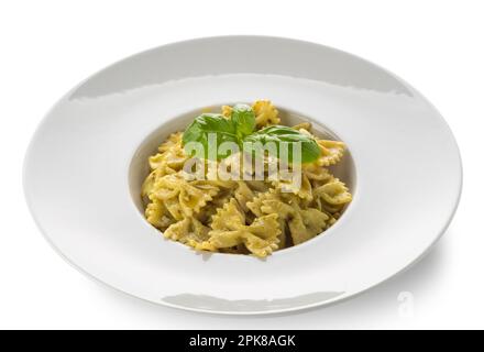 Farfalle pasta (bow tie shape) with pesto, a typical Genoese sauce of basil, pine nuts, olive oil and parmesan cheese in a white dish with clipping pa Stock Photo