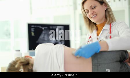 Doctor pediatrician conducting ultrasound examination of kidneys of child in clinic Stock Photo