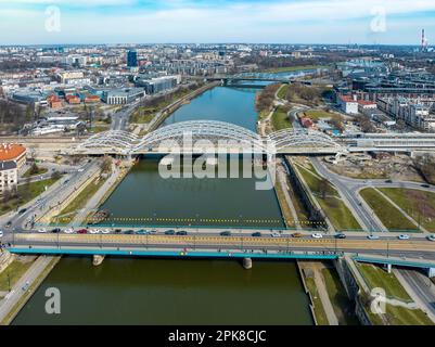 Five bridges on Vistula River in Krakow, Poland. Aerial view. Boulevards with waking people. New double railway tied-arc bridge an Kraków-Zabłocie rai Stock Photo