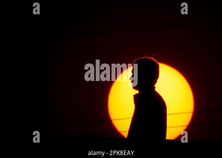 Kathmandu, Nepal. 6th Apr, 2023. A man walks along a bridge silhouetted against the setting sun on the outskirts of Kathmandu, Nepal on Thursday, April 6, 2023. (Credit Image: © Skanda Gautam/ZUMA Press Wire) EDITORIAL USAGE ONLY! Not for Commercial USAGE! Stock Photo