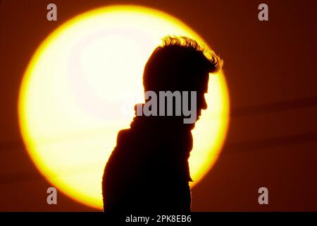 Kathmandu, Nepal. 6th Apr, 2023. A man walks along a bridge silhouetted against the setting sun on the outskirts of Kathmandu, Nepal on Thursday, April 6, 2023. (Credit Image: © Skanda Gautam/ZUMA Press Wire) EDITORIAL USAGE ONLY! Not for Commercial USAGE! Stock Photo