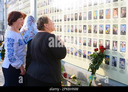 Old women mothers crying in front of the Wall of Remembrance put flowers. Meeting devoted to the anniversary of the battle of Ilovaisk (war in Donbass Stock Photo