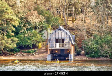 Aldourie Castle Estate Loch Ness Scotland the elaborate boat house as seen from the Loch and two yellow kayaks Stock Photo