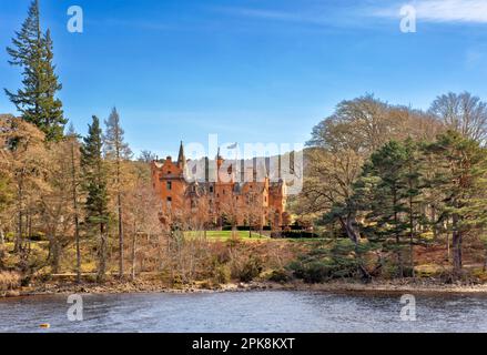 Aldourie Castle Estate Loch Ness Scotland the large castle building complete with turrets seen from the Loch Stock Photo