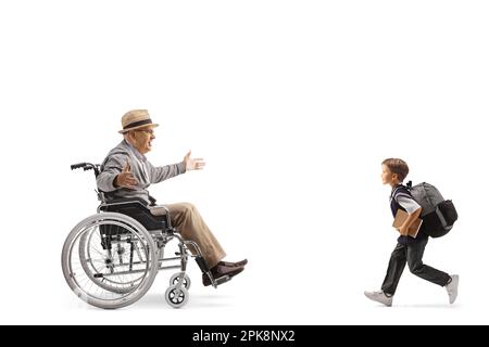 Full length profile shot of schoolboy running towards an elderly man in a wheelchair isolated on white background Stock Photo