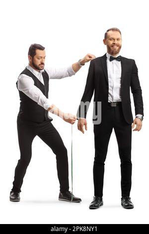 Tailor measuring a man in suit and bow tie isolated on white background Stock Photo