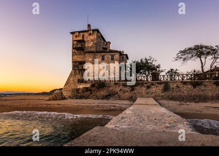 The famous Byzantine Tower of Prosphorion. The watchtower is located in Ouranoupoli Chalkidiki near Thessaloniki, Greece directly at the sea. Long exposure in the evening at sunset Stock Photo