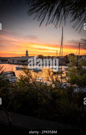 Sunset over the port and the old town of Krk on the vacation island of Krk in Croatia on the Mediterranean Sea Stock Photo