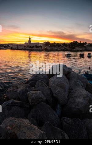 Sunset over the port and the old town of Krk on the vacation island of Krk in Croatia on the Mediterranean Sea Stock Photo