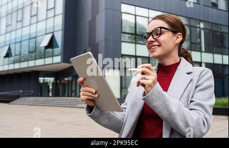 Woman architecture designer creates a new project using her digital tablet and stylus. Stock Photo