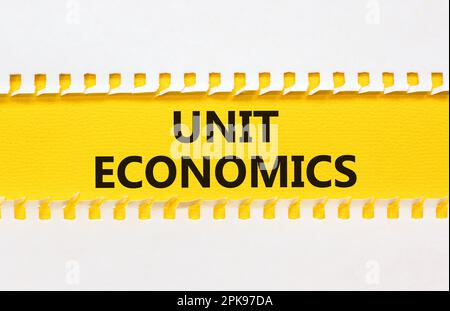 Unit economics symbol. Concept words Unit economics on yellow paper. Beautiful yellow table white background. Business and unit economics concept. Cop Stock Photo