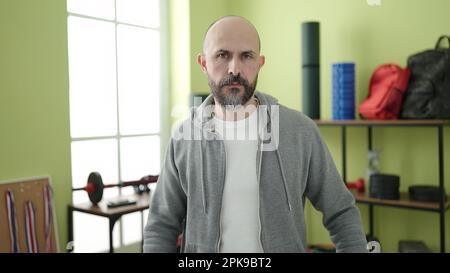 Young bald man standing with relaxed expression at sport center Stock Photo