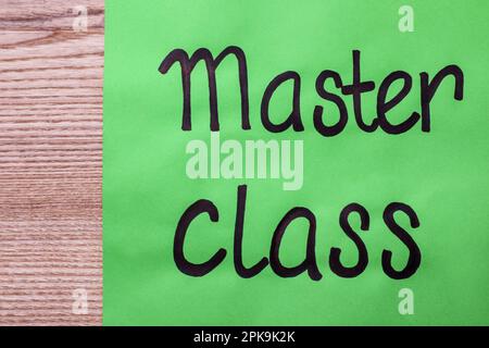 Green paper note with words Master Class on wooden table, top view Stock Photo