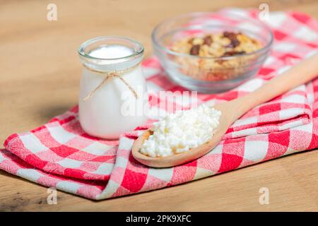 probiotic milk kefir grains, Tibetan mushrooms on wooden spoon, kefir milk in glass containers and cereals on background. health Stock Photo