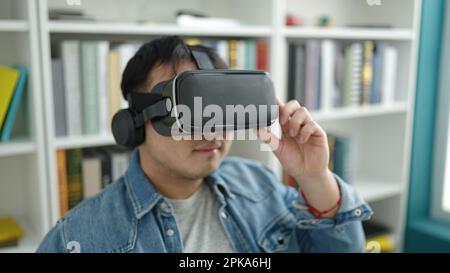 Young chinese man student using virtual reality glasses at library university Stock Photo