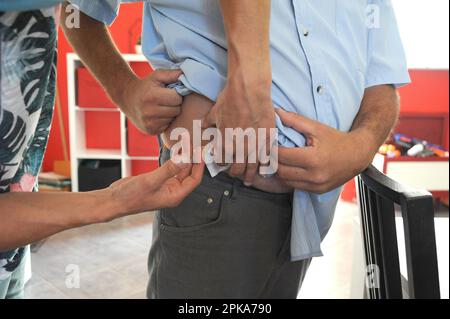 Liberal country nurse at the home of a patient for subcutaneous injection of Lovenox for the prevention of phlebitis. Stock Photo